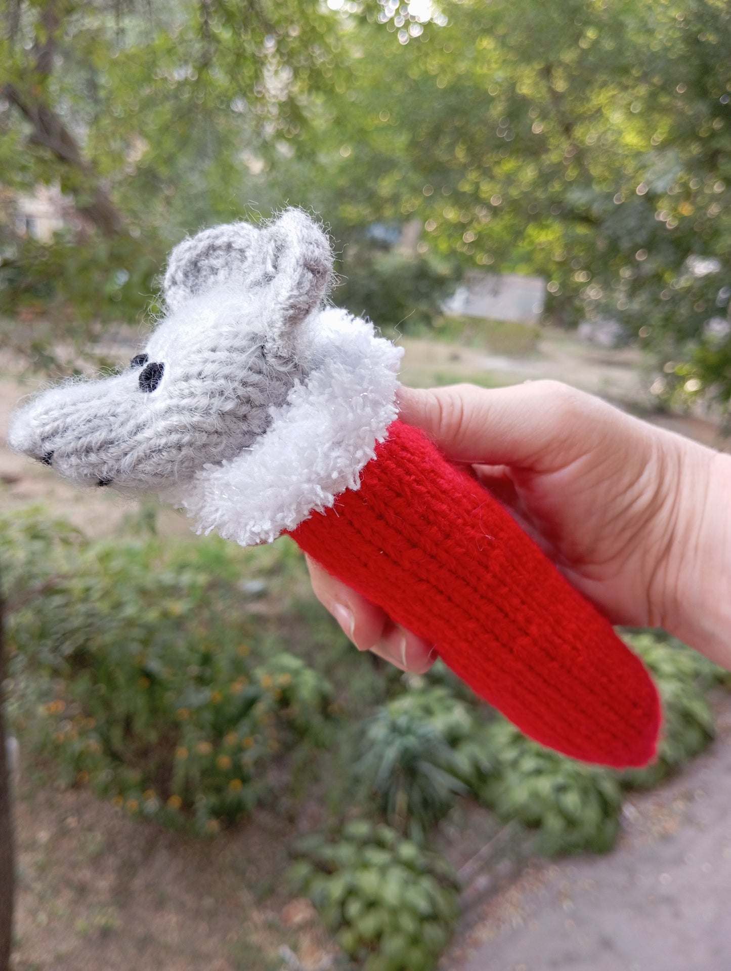 Knitted toy for a cat in the shape of a mouse wearing a Santa Claus hat