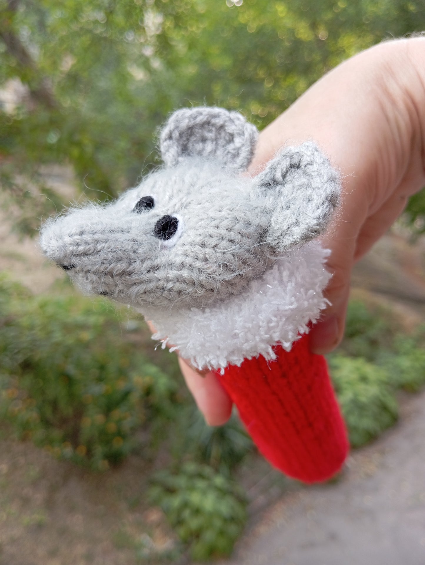 Knitted toy for a cat in the shape of a mouse wearing a Santa Claus hat