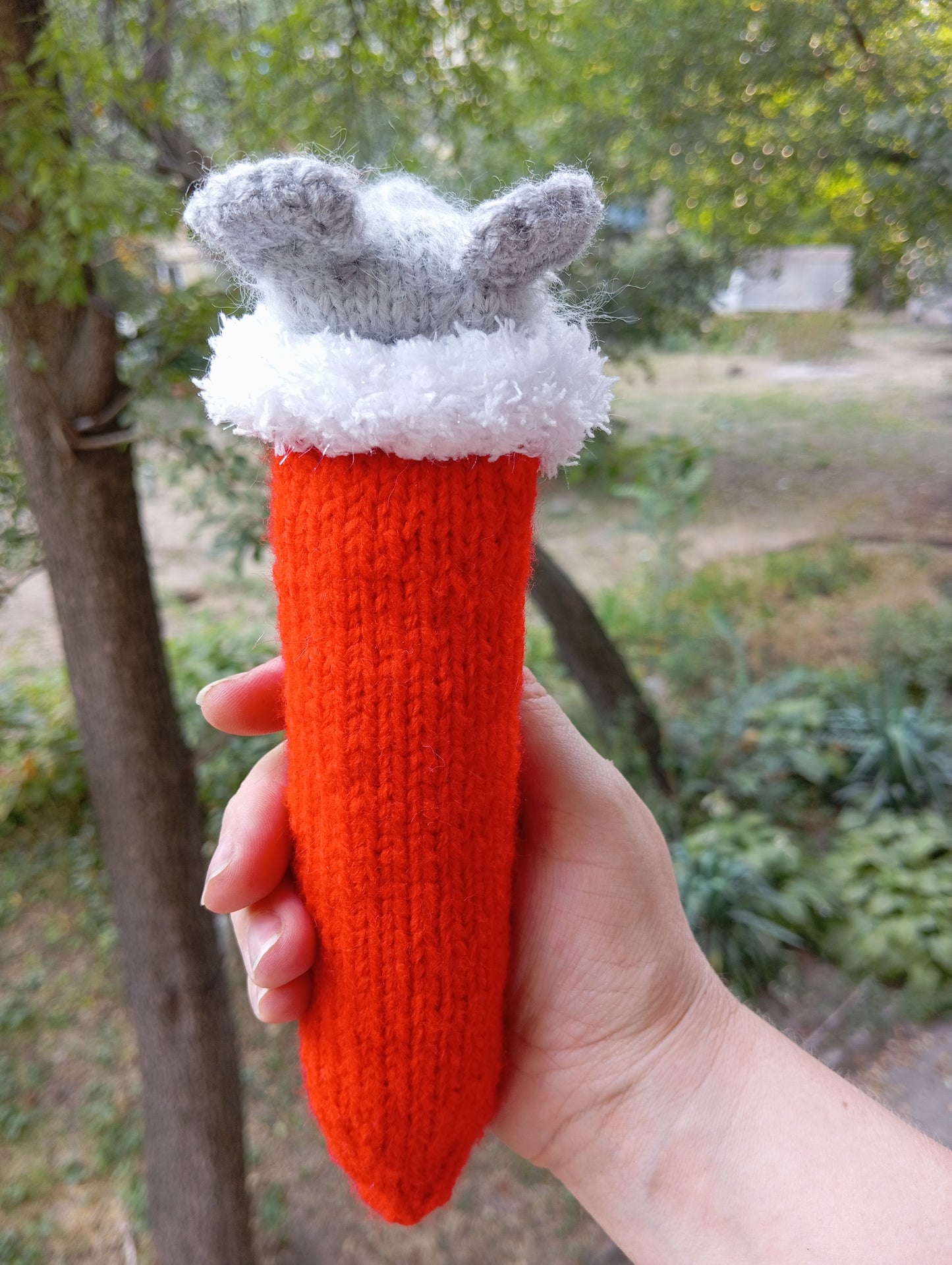 Knitted toy for a cat in the shape of a mouse wearing a Santa Claus hat