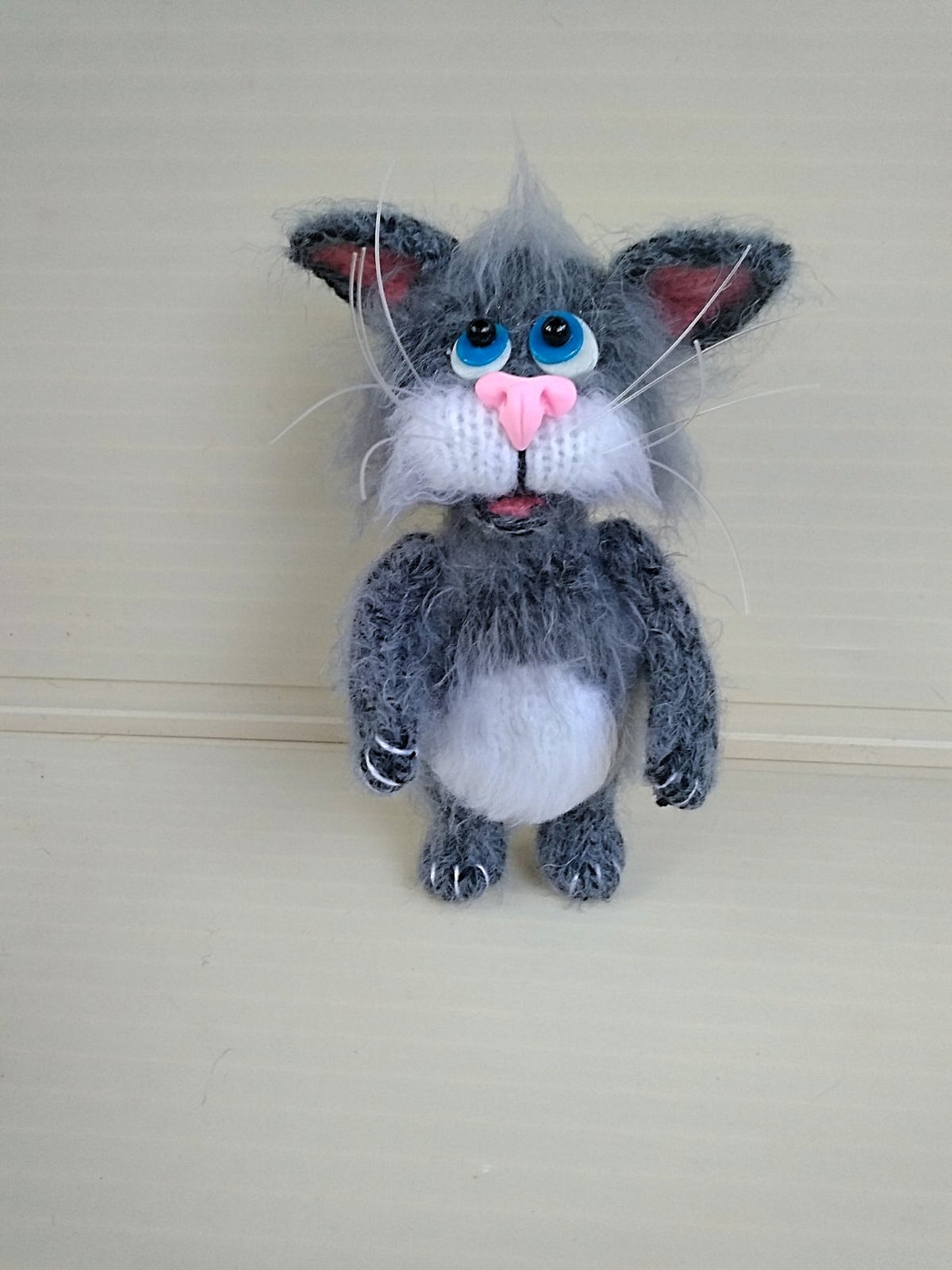 Handmade knitted gray cat is a beautiful and cute accessory that will be a wonderful decoration for any interior. It is made from high quality soft acrylic yarn which provides softness and comfort as well as durability.